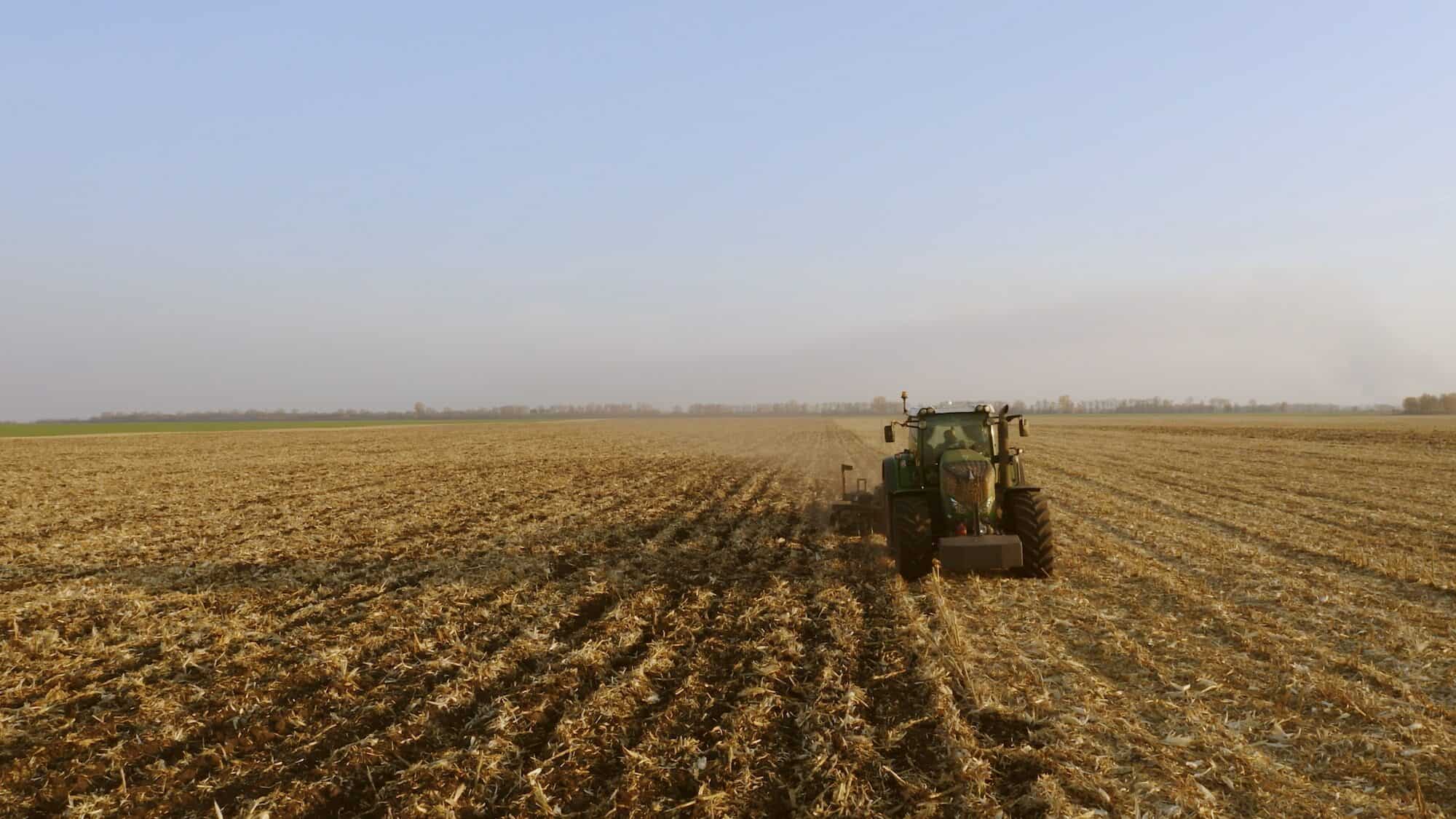 Green tractor working on field.